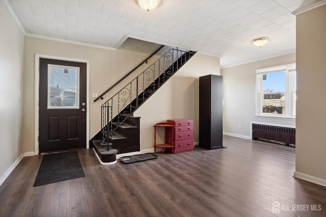 entrance foyer featuring radiator, baseboards, ornamental molding, and dark wood-type flooring