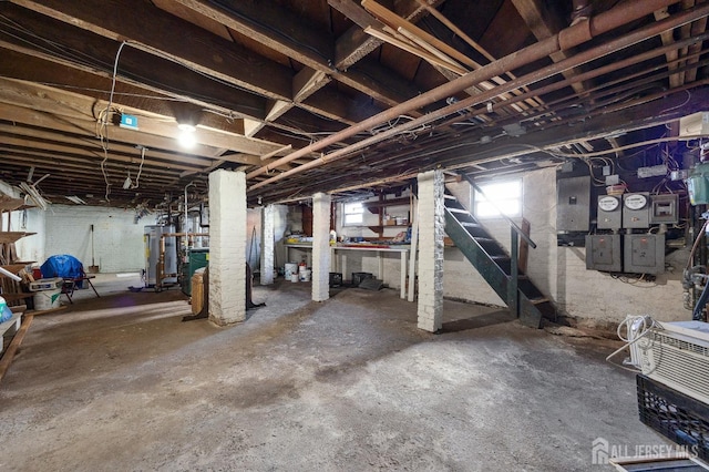 below grade area featuring stairway, gas water heater, and electric panel