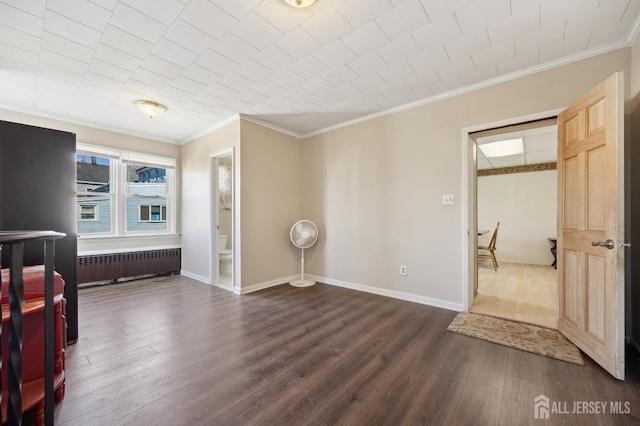 bedroom with radiator, dark wood finished floors, and baseboards