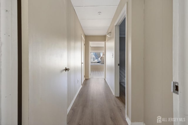 hallway with baseboards and wood finished floors