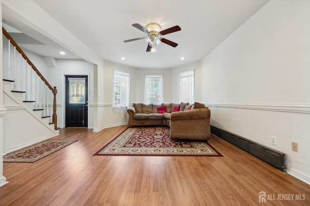 living area with stairs, recessed lighting, wood finished floors, and baseboards