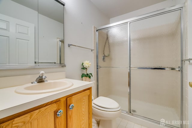 bathroom featuring toilet, a stall shower, and vanity