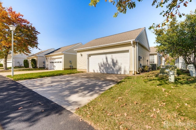 view of front of house featuring a front yard, central AC unit, and a garage