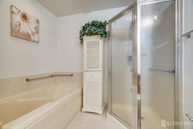 bathroom with tile patterned floors, a shower stall, and a garden tub