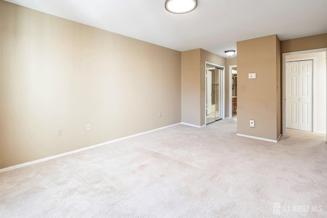 unfurnished bedroom with light carpet and two closets