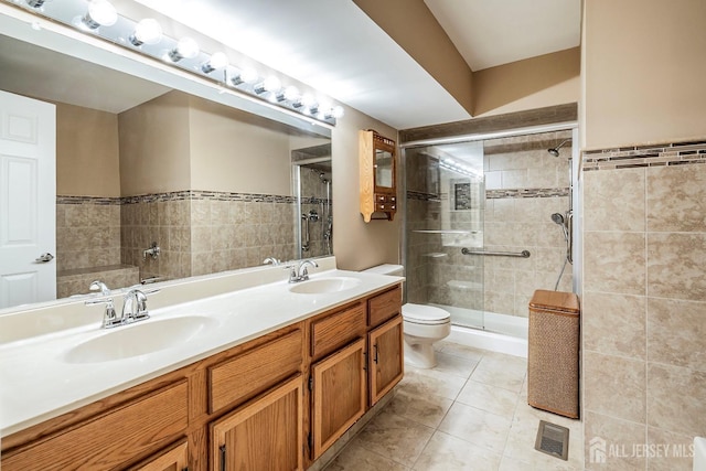 bathroom featuring tile patterned floors, toilet, vanity, and walk in shower