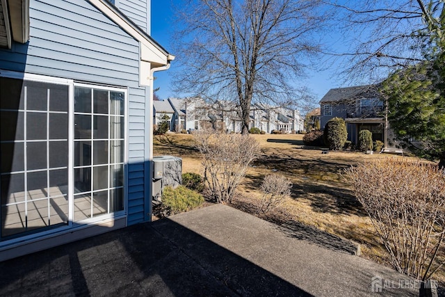 view of patio / terrace with cooling unit and a residential view