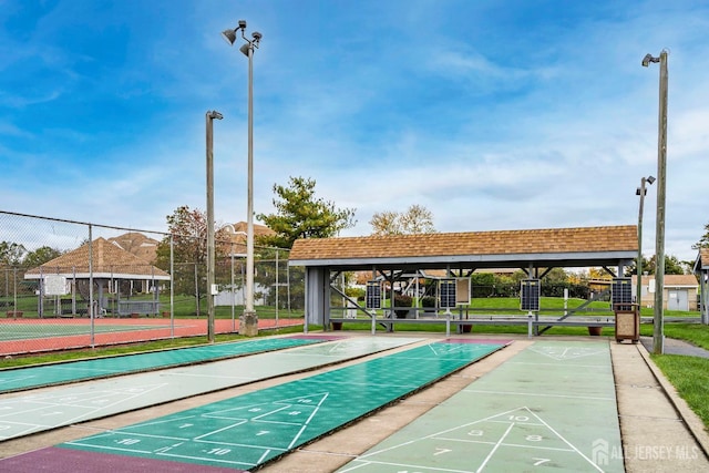 view of home's community with fence and shuffleboard