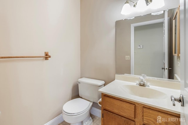 bathroom featuring vanity, toilet, baseboards, and tile patterned flooring