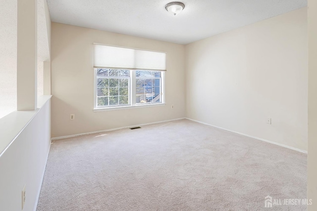 unfurnished room with light carpet and a textured ceiling