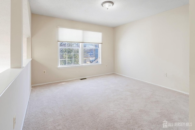 unfurnished room featuring baseboards, visible vents, and carpet floors