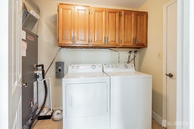 laundry area with baseboards, washing machine and dryer, light tile patterned flooring, and cabinet space