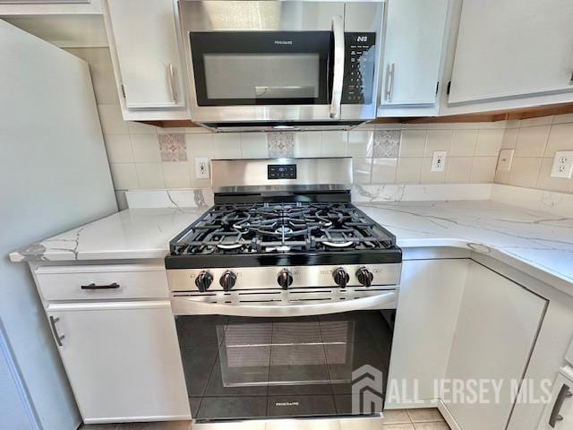 13-B Ashbourne Dr Unit B, Monroe, NJ 08831 - kitchen featuring appliances with stainless steel finishes, white cabinetry, light stone countertops, and tasteful backsplash