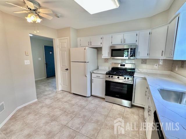 13-B Ashbourne Dr Unit B, Monroe, NJ 08831 - kitchen with stainless steel appliances, a ceiling fan, light stone counters, tasteful backsplash, and white cabinets