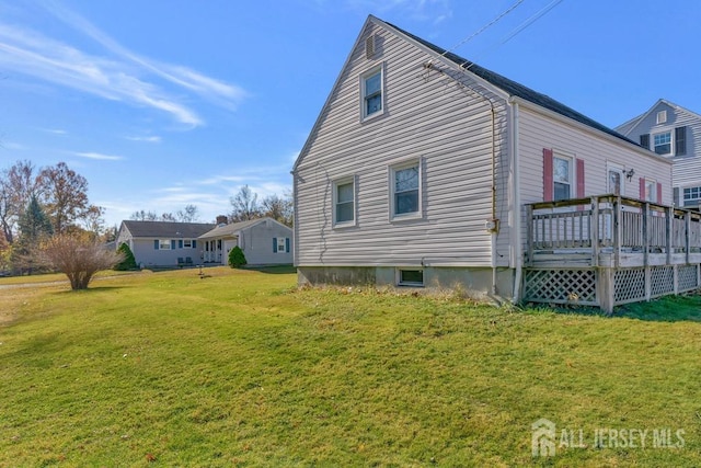 view of side of home featuring a deck and a lawn