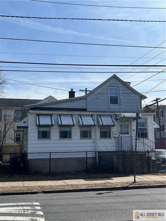 view of front of property featuring a chimney and fence