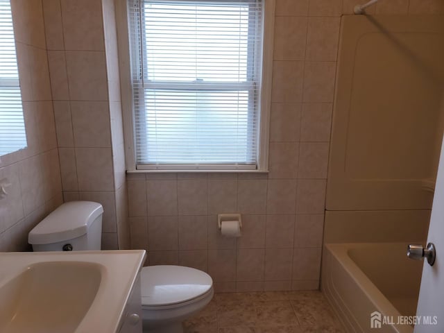 251 Henry St, South Amboy, NJ 08879 - bathroom featuring tile walls, toilet, tile patterned floors, vanity, and shower / washtub combination