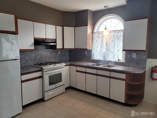 251 Henry St, South Amboy, NJ 08879 - kitchen featuring white appliances, a sink, under cabinet range hood, dark countertops, and white cabinetry