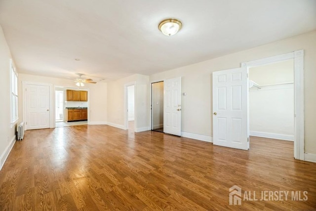 251 Henry St, South Amboy, NJ 08879 - unfurnished living room featuring radiator heating unit, wood finished floors, baseboards, and ceiling fan
