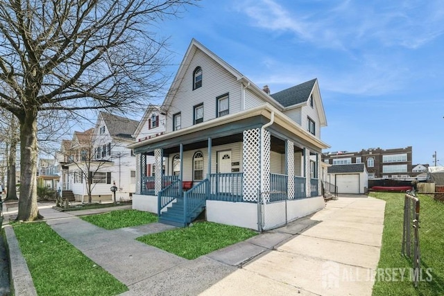 251 Henry St, South Amboy, NJ 08879 - view of front of house with a porch, driveway, an outdoor structure, a front lawn, and a detached garage
