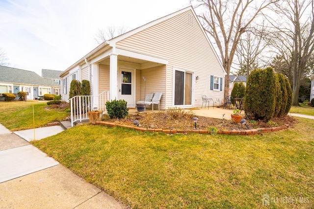 view of front of home with a front yard and a patio area