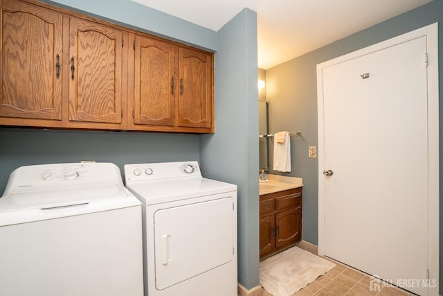 clothes washing area featuring cabinets and separate washer and dryer