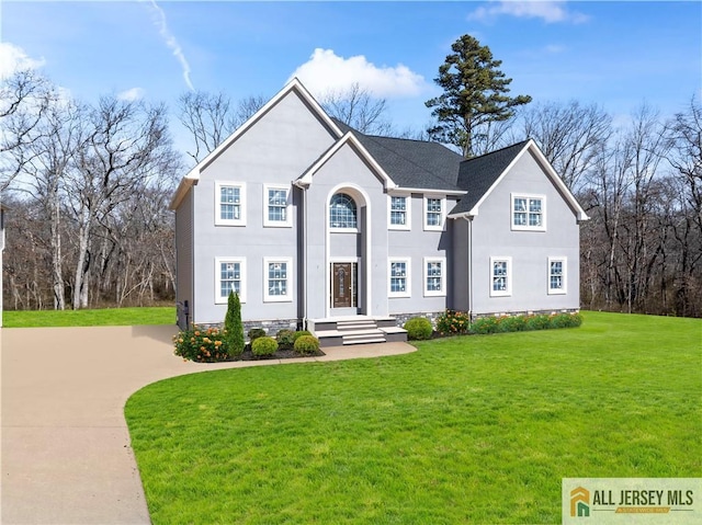 view of front of house featuring a front lawn and stucco siding