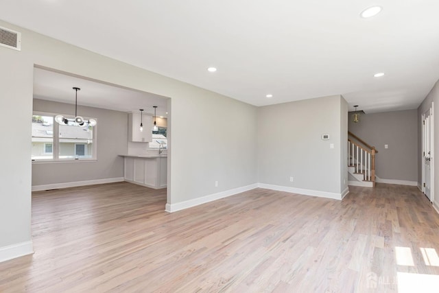 141 Day St, South Plainfield, NJ 07080 - unfurnished living room featuring stairway, light wood-type flooring, baseboards, recessed lighting, and a chandelier