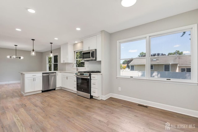 141 Day St, South Plainfield, NJ 07080 - kitchen featuring stainless steel appliances, baseboards, a peninsula, light wood finished floors, and recessed lighting