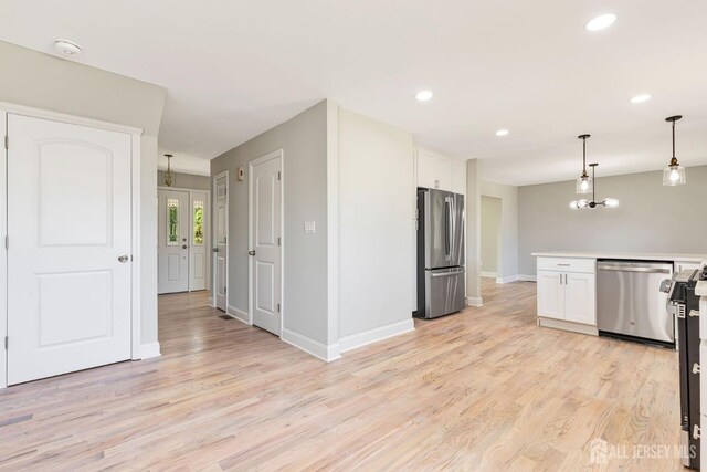 141 Day St, South Plainfield, NJ 07080 - kitchen featuring appliances with stainless steel finishes, white cabinetry, light wood finished floors, hanging light fixtures, and recessed lighting