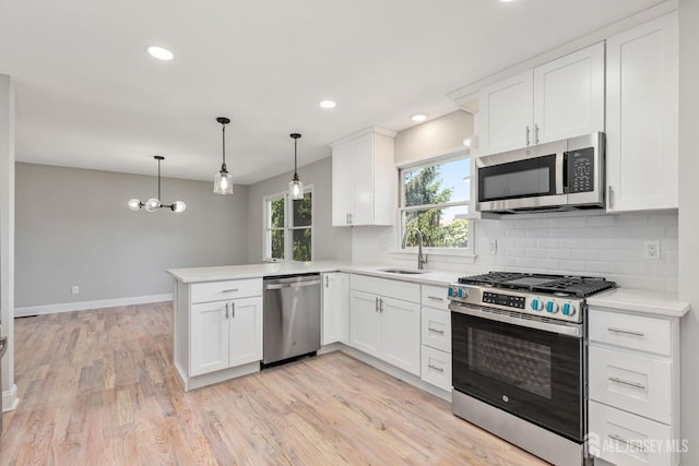 141 Day St, South Plainfield, NJ 07080 - kitchen with stainless steel appliances, a peninsula, light countertops, tasteful backsplash, and white cabinets