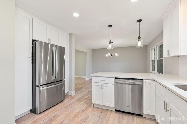 141 Day St, South Plainfield, NJ 07080 - kitchen with appliances with stainless steel finishes, a peninsula, white cabinets, light countertops, and recessed lighting