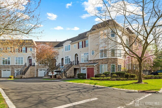 4 Sandra Ct Unit 2743, Old Bridge, NJ 08857 - view of building exterior with stairs, asphalt driveway, a residential view, and an attached garage
