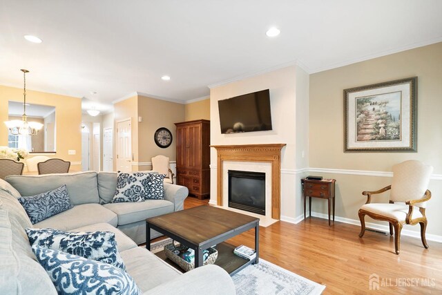 4 Sandra Ct Unit 2743, Old Bridge, NJ 08857 - living area featuring light wood-type flooring, a chandelier, a fireplace with flush hearth, recessed lighting, and ornamental molding