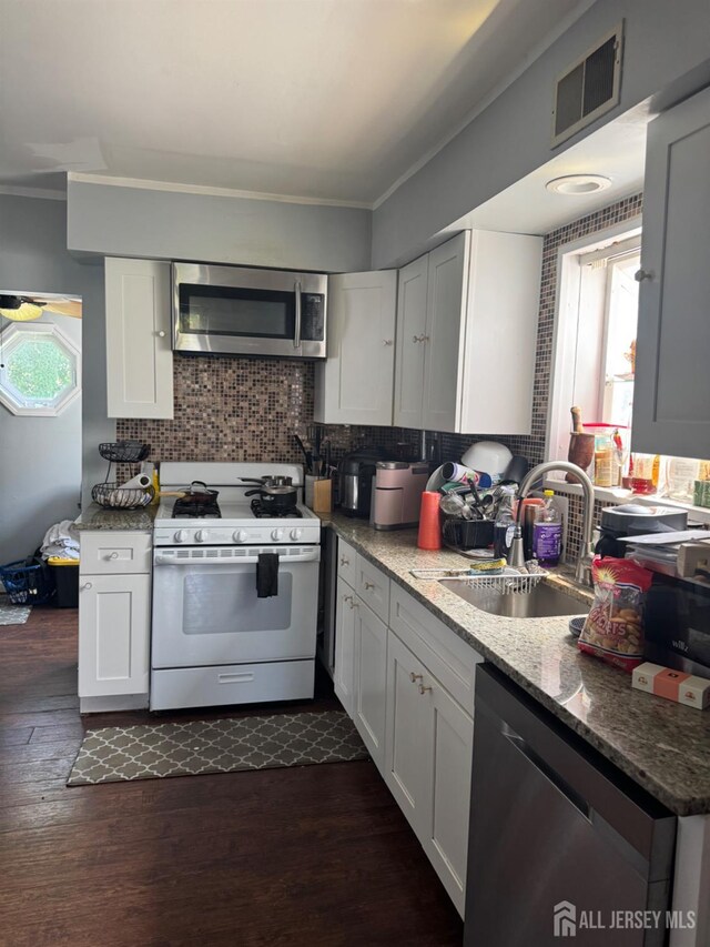 198 Strawberry Hill Ave, Woodbridge Proper, NJ 07095 - kitchen featuring white gas range oven, stainless steel microwave, dishwasher, ornamental molding, and dark wood-type flooring