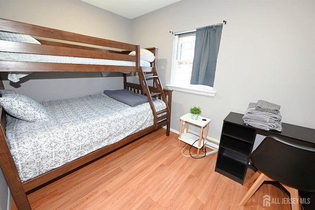 bedroom with wood finished floors and baseboards
