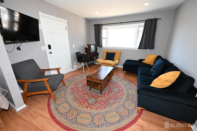 living area with wood finished floors, recessed lighting, and baseboards