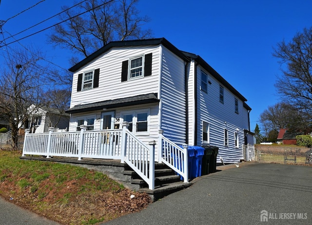 traditional-style home featuring fence