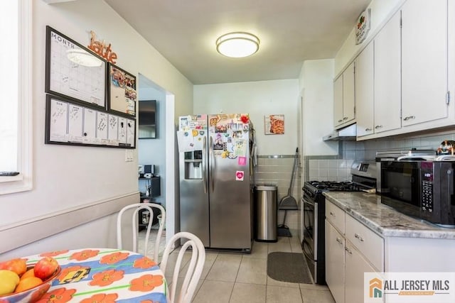 1 Berkley Blvd, Iselin, NJ 08830 - kitchen with stainless steel appliances, under cabinet range hood, light tile patterned floors, white cabinetry, and decorative backsplash