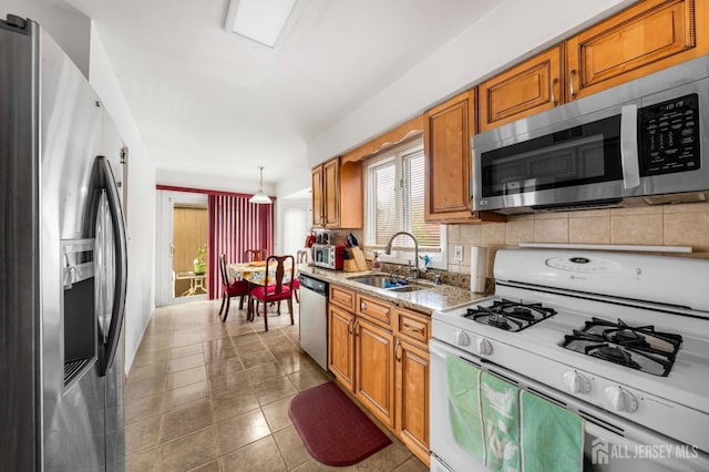 66 Riverbend Dr, North Brunswick, NJ 08902 - kitchen with appliances with stainless steel finishes, backsplash, brown cabinetry, tile patterned floors, and light stone counters
