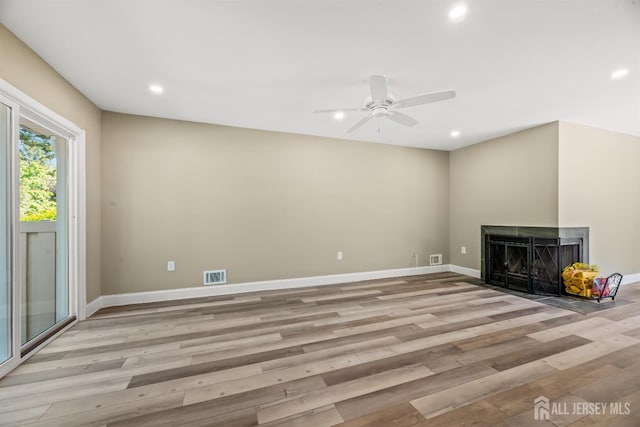 1018 Schmidt Ln, North Brunswick, NJ 08902 - unfurnished living room with light wood-type flooring, a multi sided fireplace, recessed lighting, a ceiling fan, and baseboards