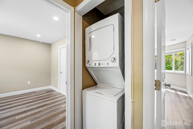1018 Schmidt Ln, North Brunswick, NJ 08902 - clothes washing area with stacked washer / dryer, wood finished floors, baseboards, and recessed lighting