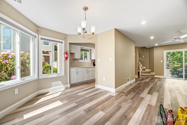 1018 Schmidt Ln, North Brunswick, NJ 08902 - unfurnished dining area featuring light wood-style floors, a chandelier, stairway, healthy amount of natural light, and recessed lighting