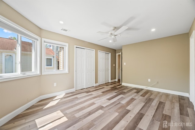 1018 Schmidt Ln, North Brunswick, NJ 08902 - unfurnished bedroom with multiple closets, baseboards, light wood-type flooring, recessed lighting, and ceiling fan