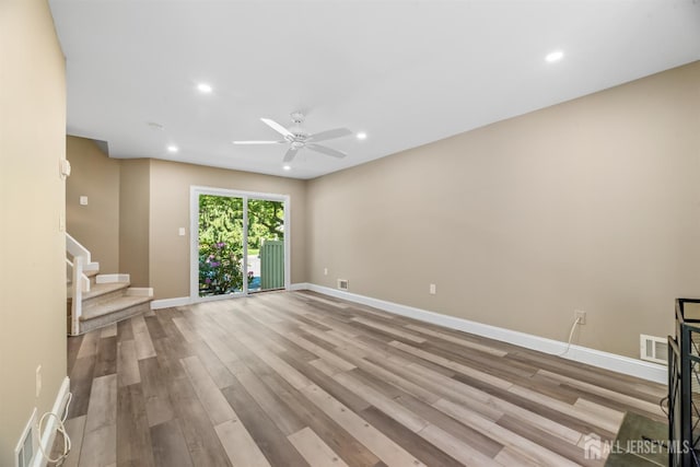 1018 Schmidt Ln, North Brunswick, NJ 08902 - unfurnished living room featuring a ceiling fan, wood finished floors, stairway, baseboards, and recessed lighting