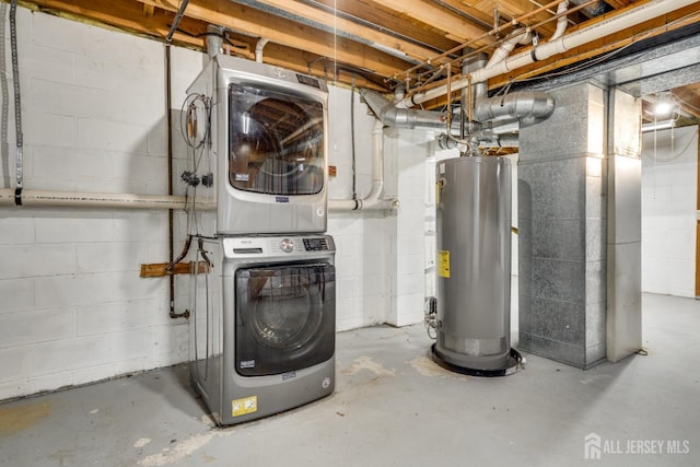 unfinished below grade area featuring water heater and stacked washer / dryer