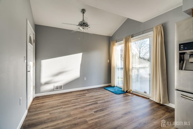 unfurnished dining area featuring visible vents, baseboards, lofted ceiling, and wood finished floors