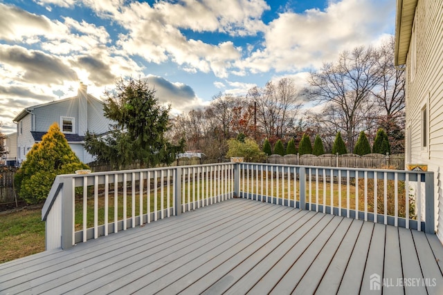 wooden deck featuring a lawn and a fenced backyard