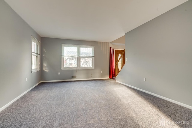 unfurnished room featuring stairway, baseboards, carpet, and visible vents