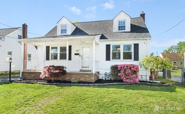 cape cod house with roof with shingles, a chimney, a porch, and a front yard